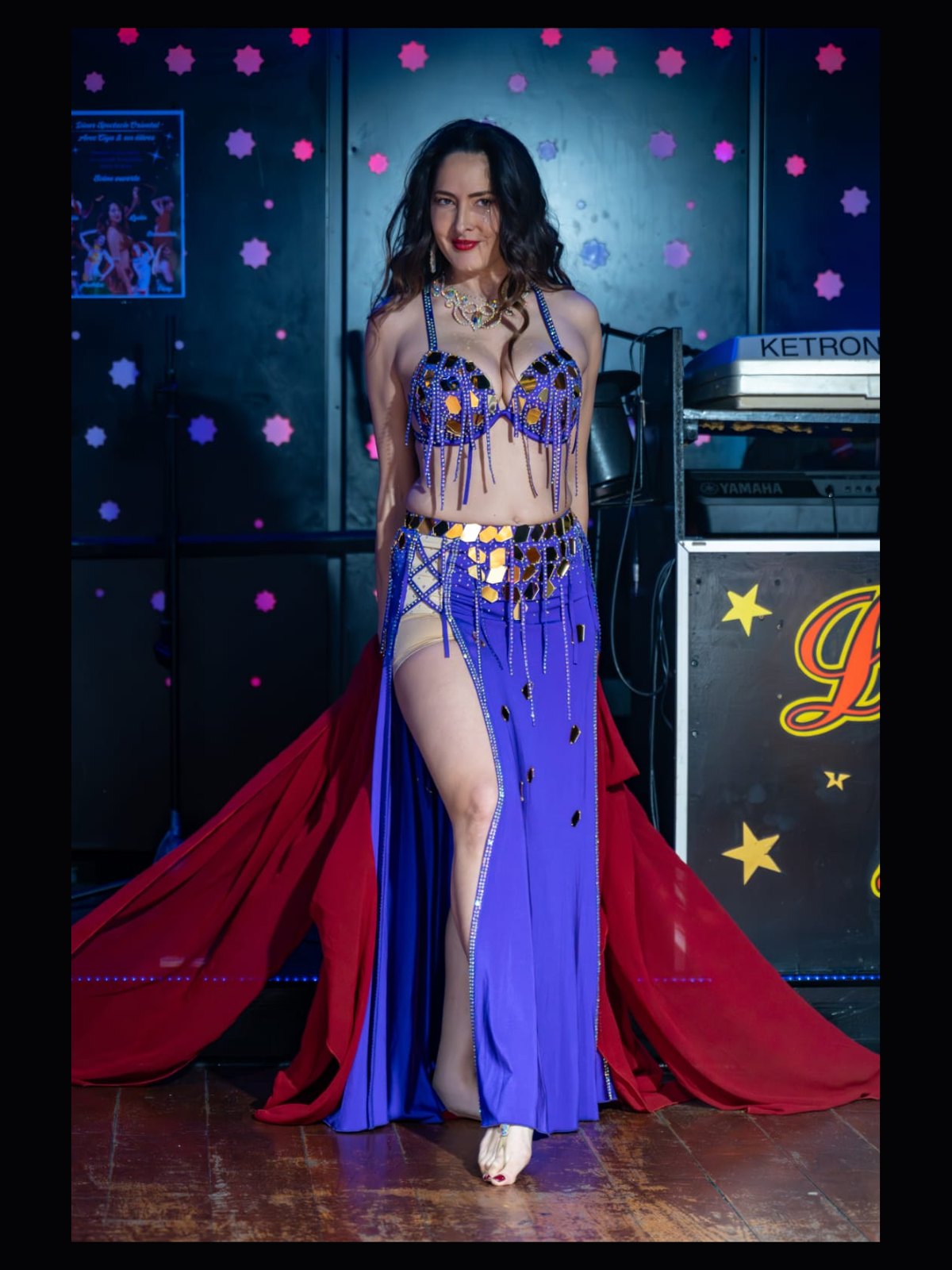 Ciya en costume bleu et or avec un voile rouge, lors d'un dîner-spectacle oriental